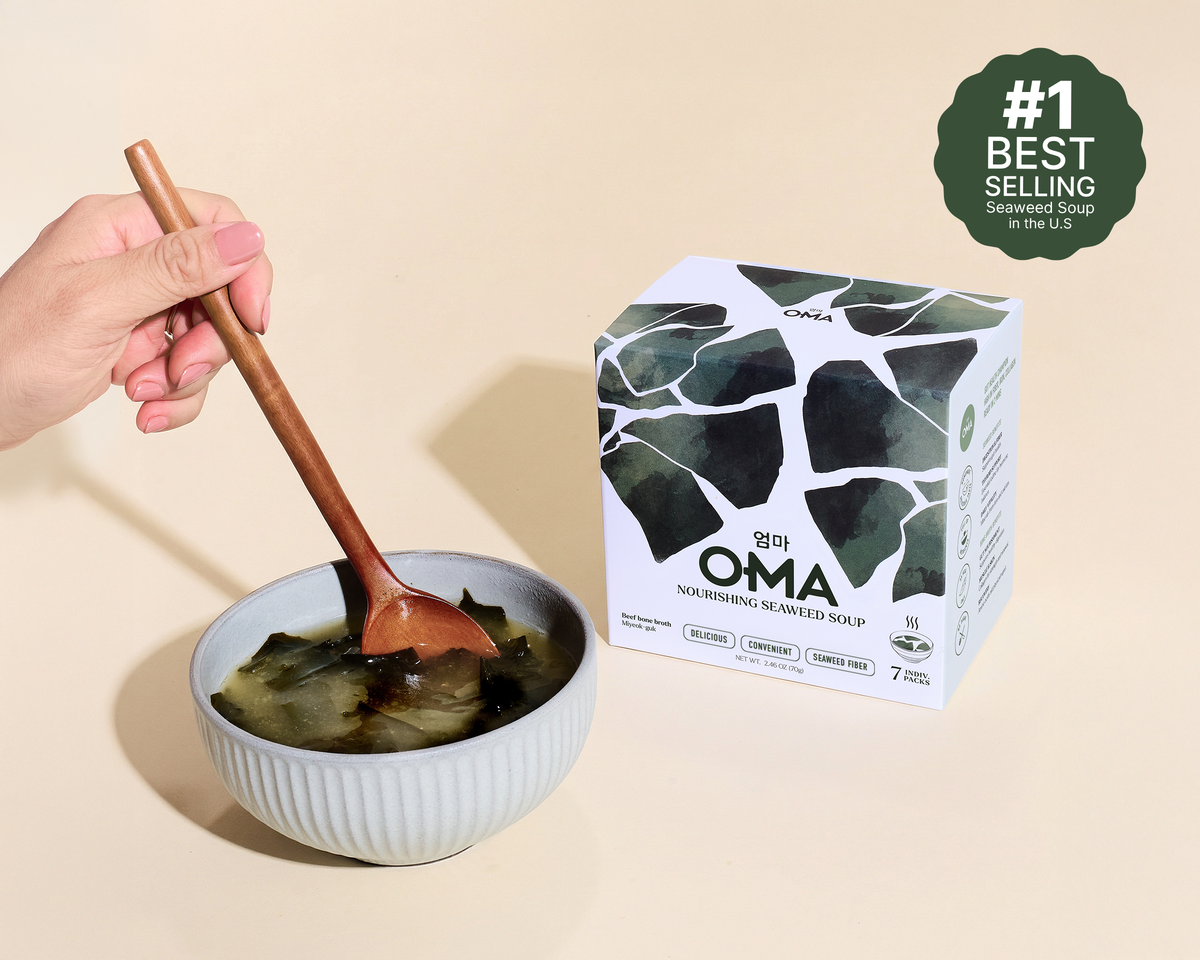 Bowl of seaweed soup with a wooden spoon and OMA seaweed soup packaging on a beige background