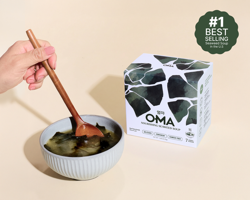 Bowl of OMA seaweed soup with a wooden spoon next to the Beef Bone Broth box
